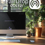 Computerbildschirm mit PairDrop-Logo und Docker-Symbol in einem modernen Büro mit Pflanzen.